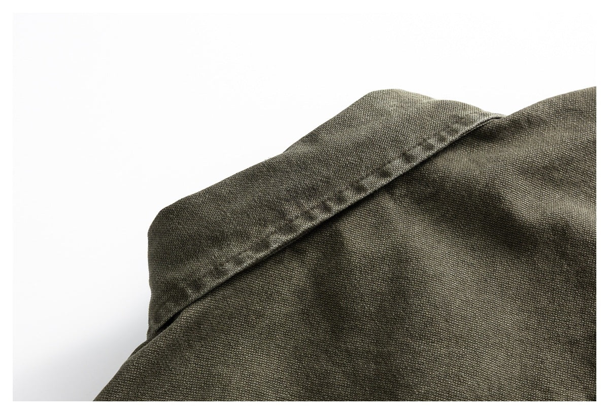 Close-up of the olive-gray shirt shoulder and collar seam.