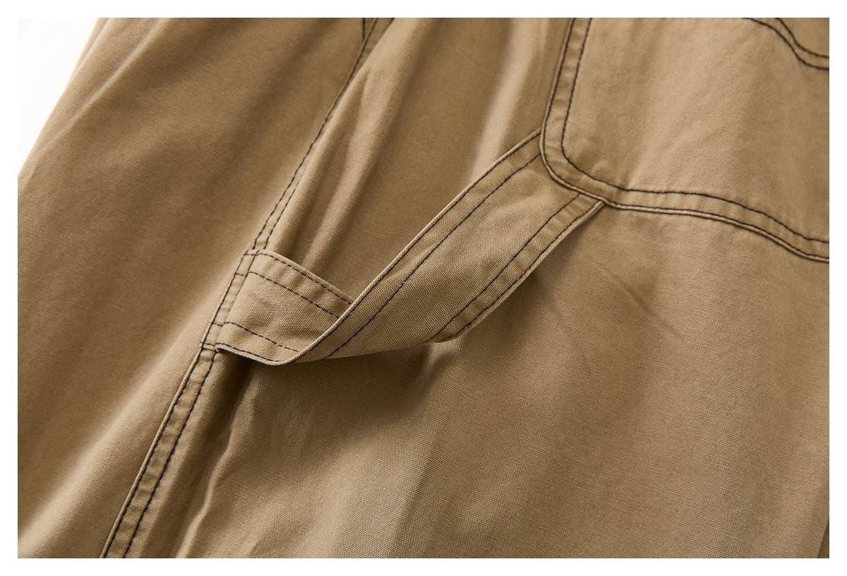 Close-up of a tan pants pocket opening and adjoining seams with dark contrast stitching.