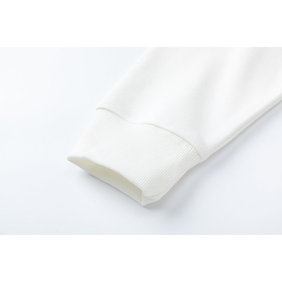 Close-up of a white sleeve ending in a wide ribbed cuff.