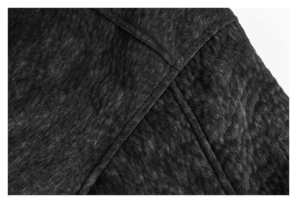 Close-up of the jacket's dark mottled fabric and intersecting stitched seams.