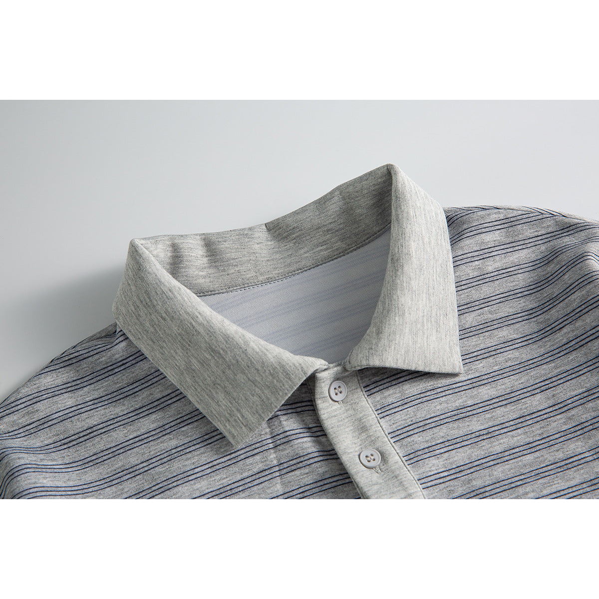 Close-up of a light gray striped long-sleeve polo shirt collar and button placket.