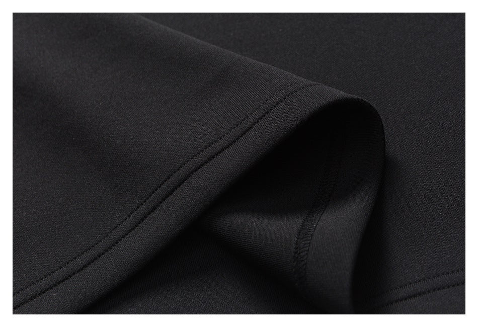 Close-up of a curved stitched edge and folded seam on black fabric.