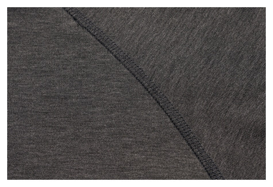 Close-up of the charcoal top's curved raglan seam and stitching.
