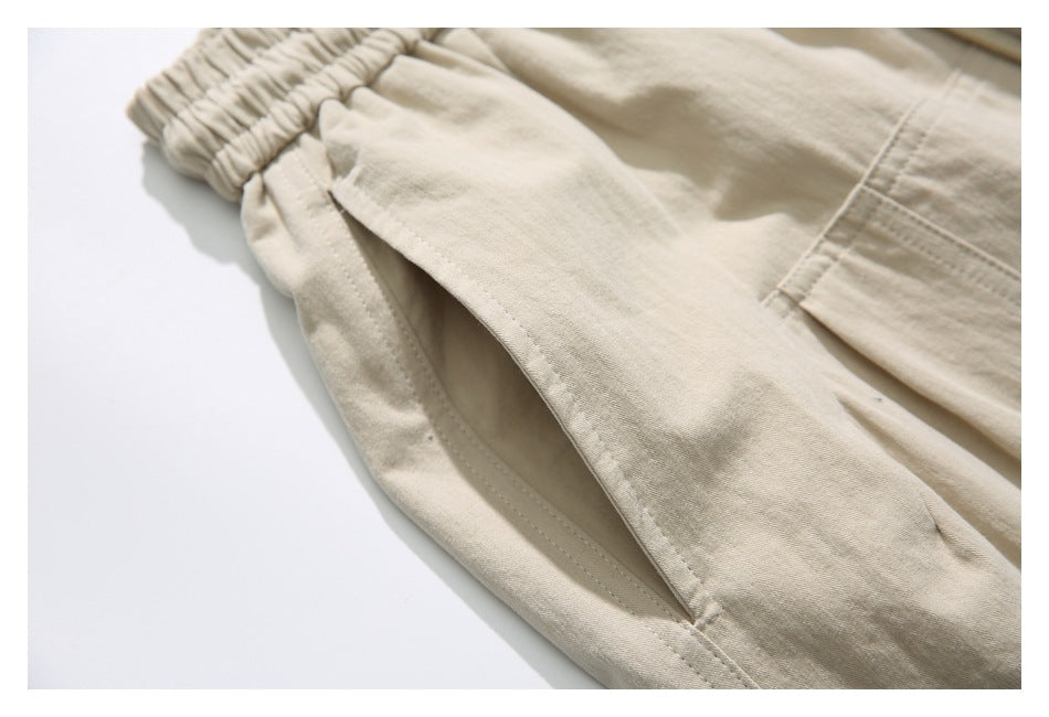 Close-up of a beige pants pocket opening beside the gathered elastic waistband.