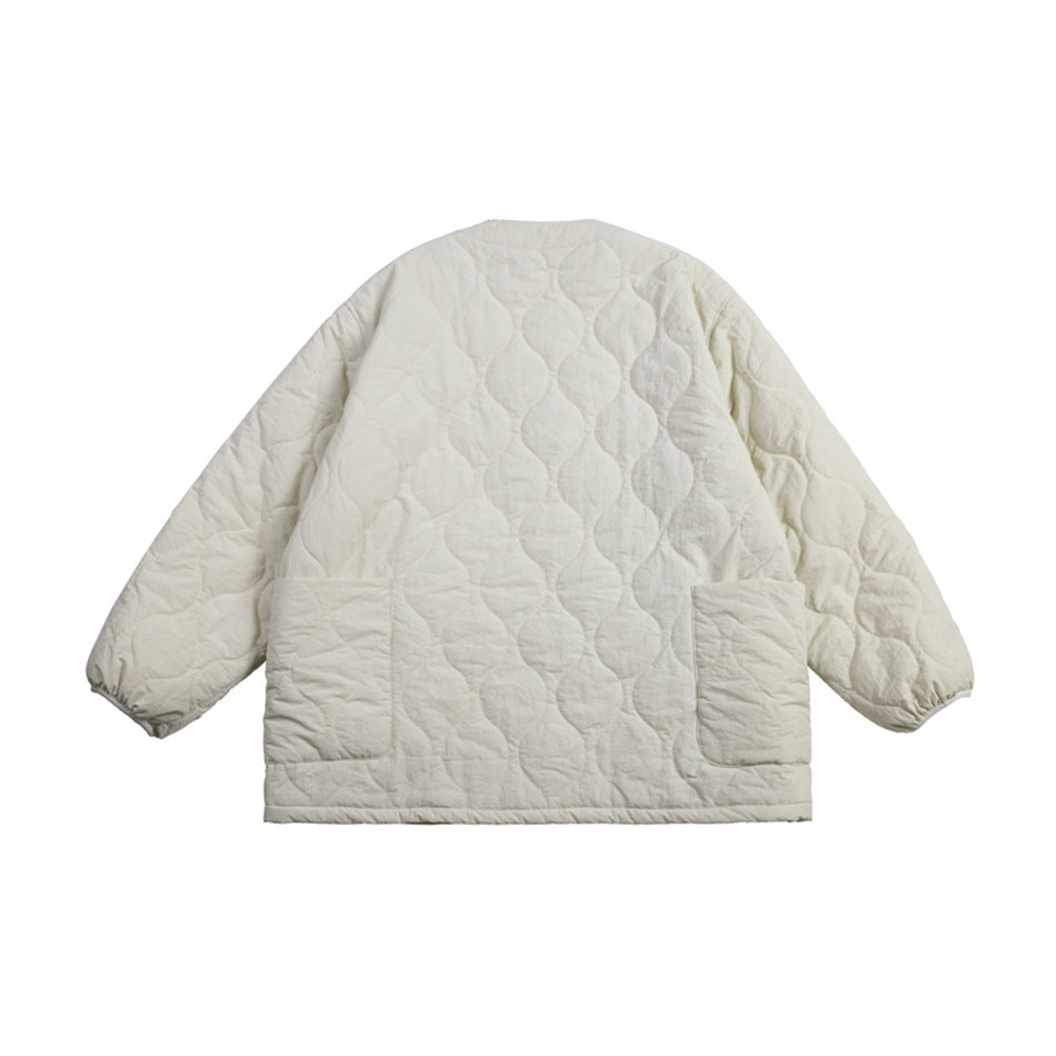 Back view of an ivory quilted jacket with a circular stitch pattern, long sleeves, and two patch pockets.