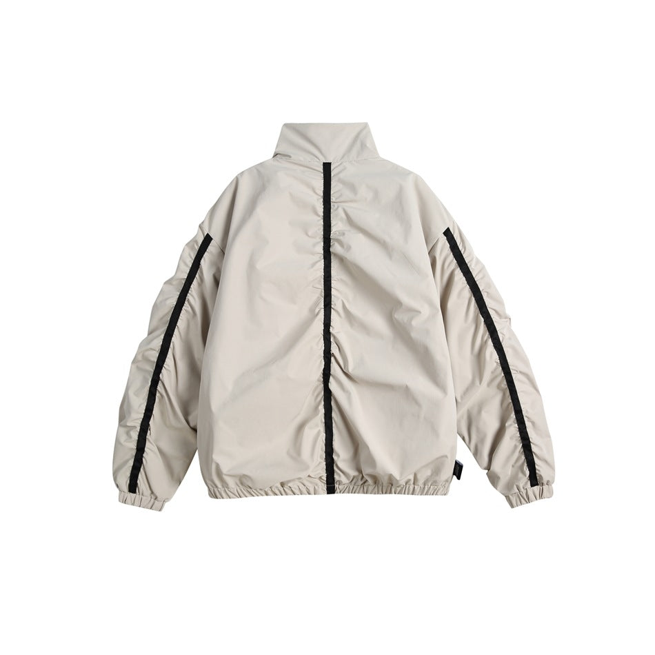 Back view of an off-white jacket with black vertical sleeve and center-back trim.