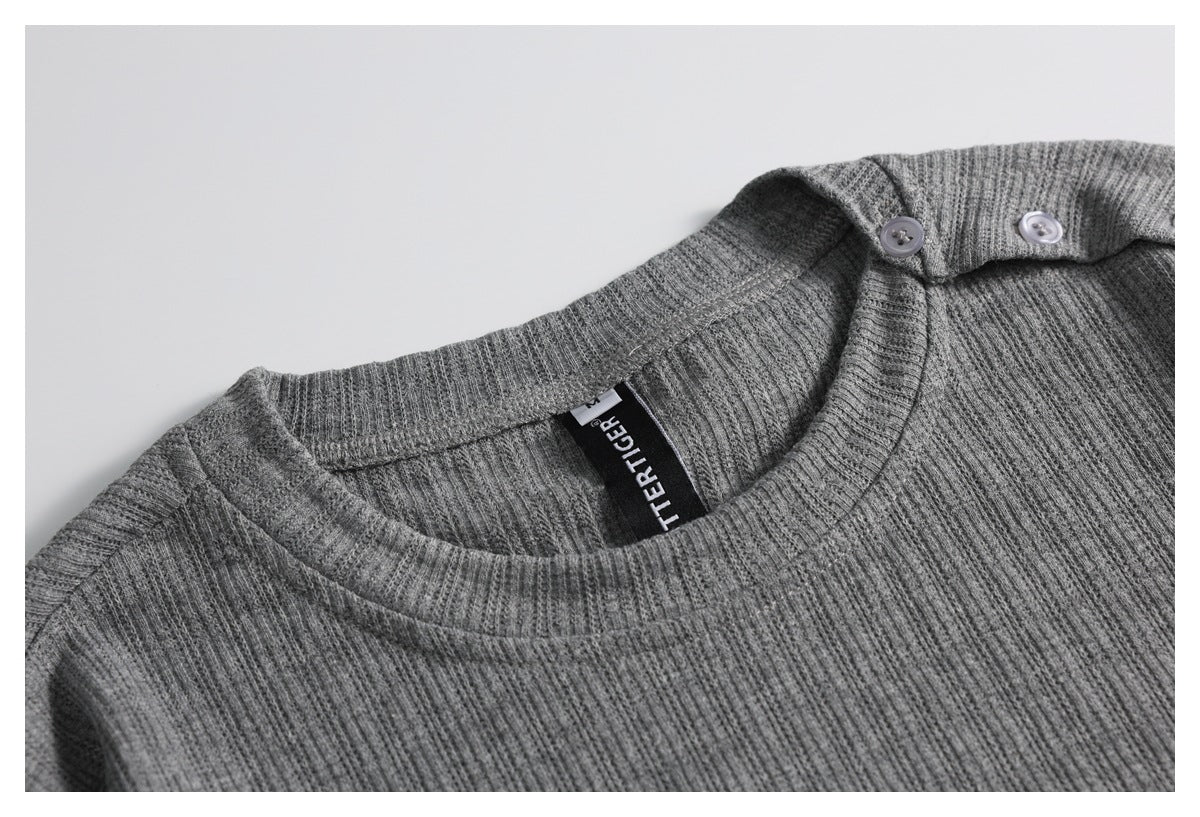 Close-up of a gray ribbed crew-neck T-shirt showing the neckline, shoulder buttons, and neck label.