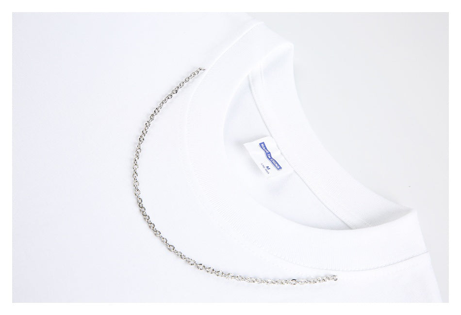 Close-up of a white T-shirt collar with a silver chain detail and sewn-in neck label.