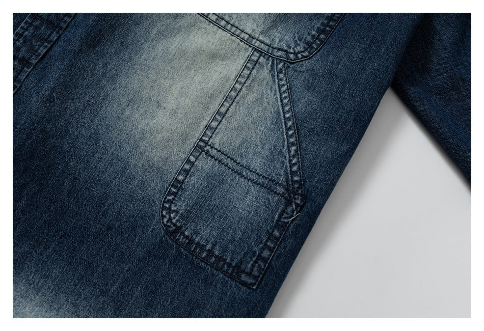 Close-up of a faded blue denim patch pocket with dark double stitching.