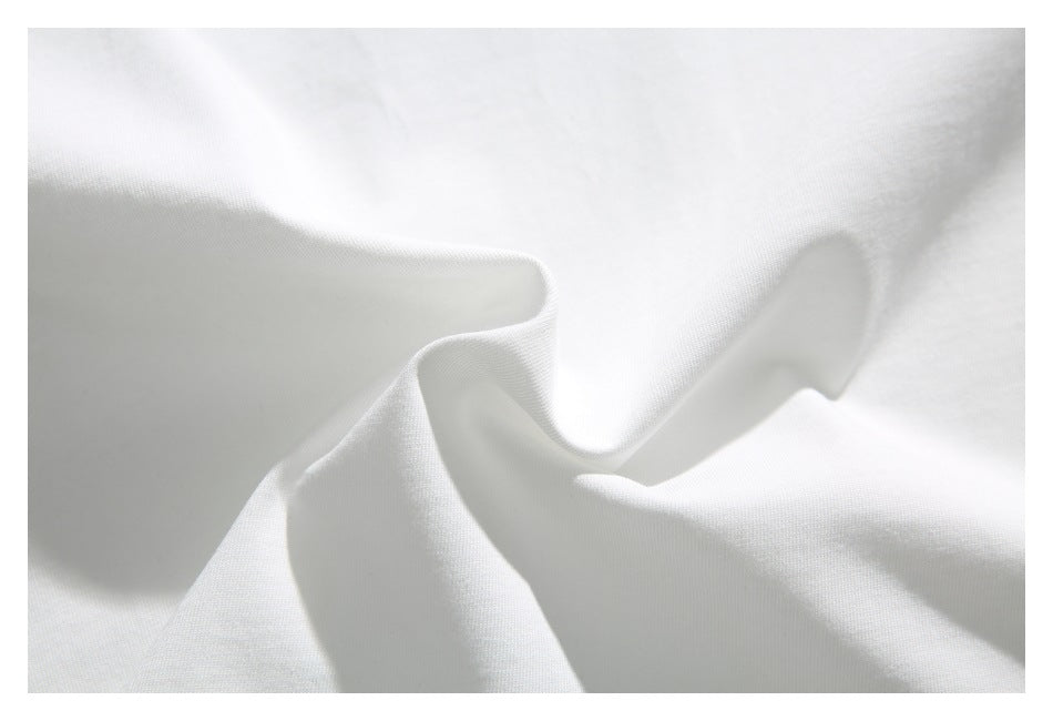 Close-up of softly draped white shirt fabric showing its surface and folds.