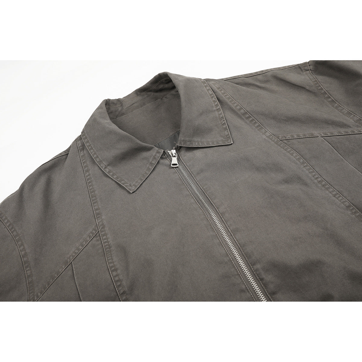 Close-up of a gray jacket's pointed collar, front zipper, and stitched panels.
