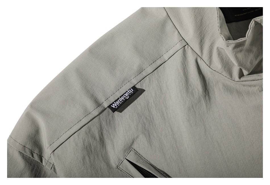 Close-up of the jacket shoulder seam and small black woven brand tab.