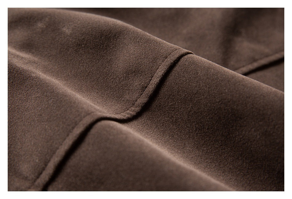 Close-up of a curved stitched seam on a dark brown garment.