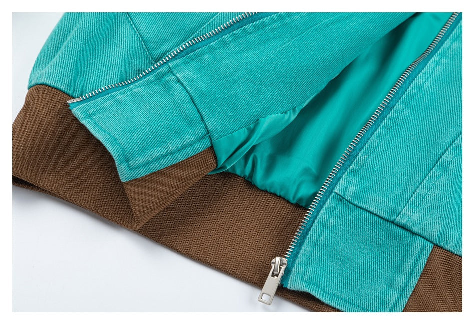 Close-up of a turquoise jacket with a silver zipper, brown ribbed hem, and matching turquoise lining.