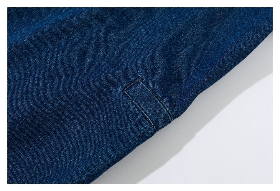 Close-up of dark blue denim with a stitched seam and visible twill texture.
