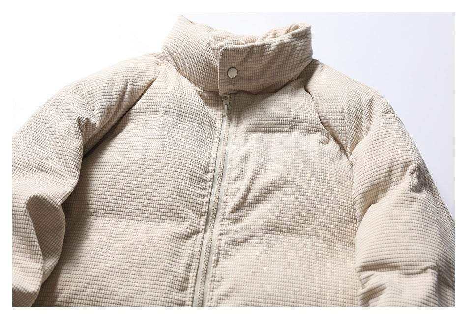 Cropped front view of a light beige textured jacket with a high collar, center zipper and snap closure.