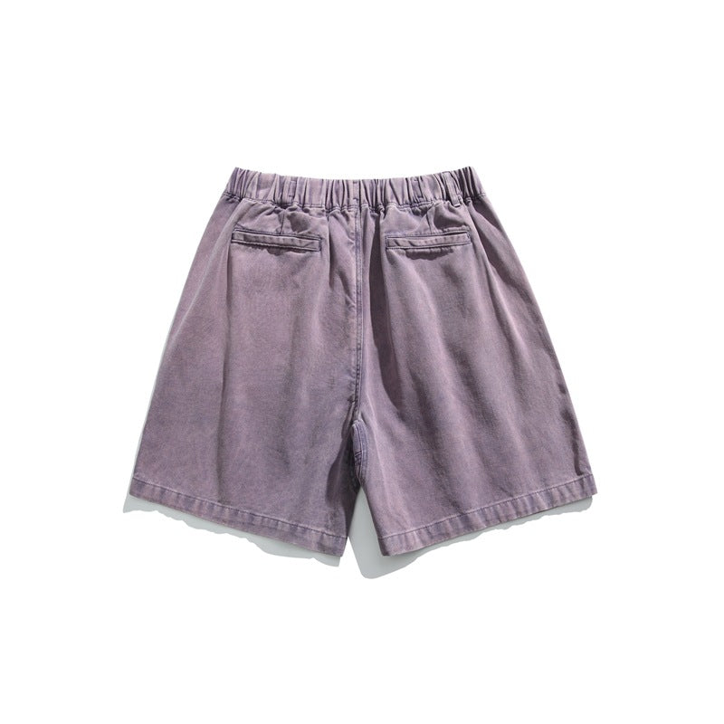 Rear view of muted purple shorts with an elastic waistband and two back pockets, displayed flat on white.