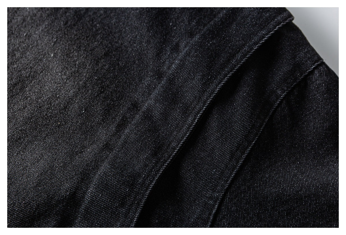 Close-up of black textured fabric with a raised diagonal seam and folded edge.