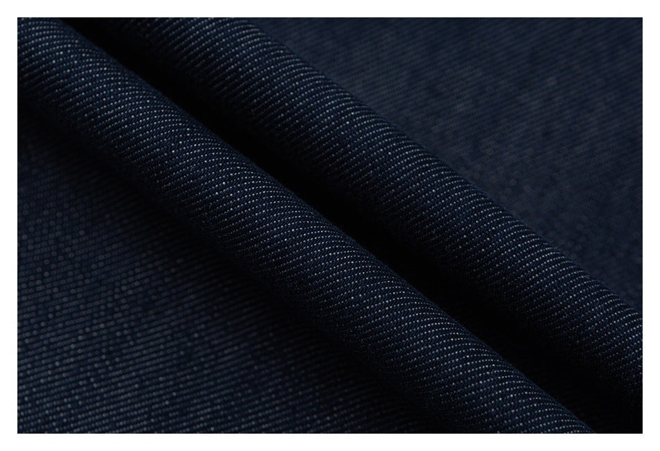 Close-up of dark navy fabric with a fine, tightly woven texture and diagonal folds.