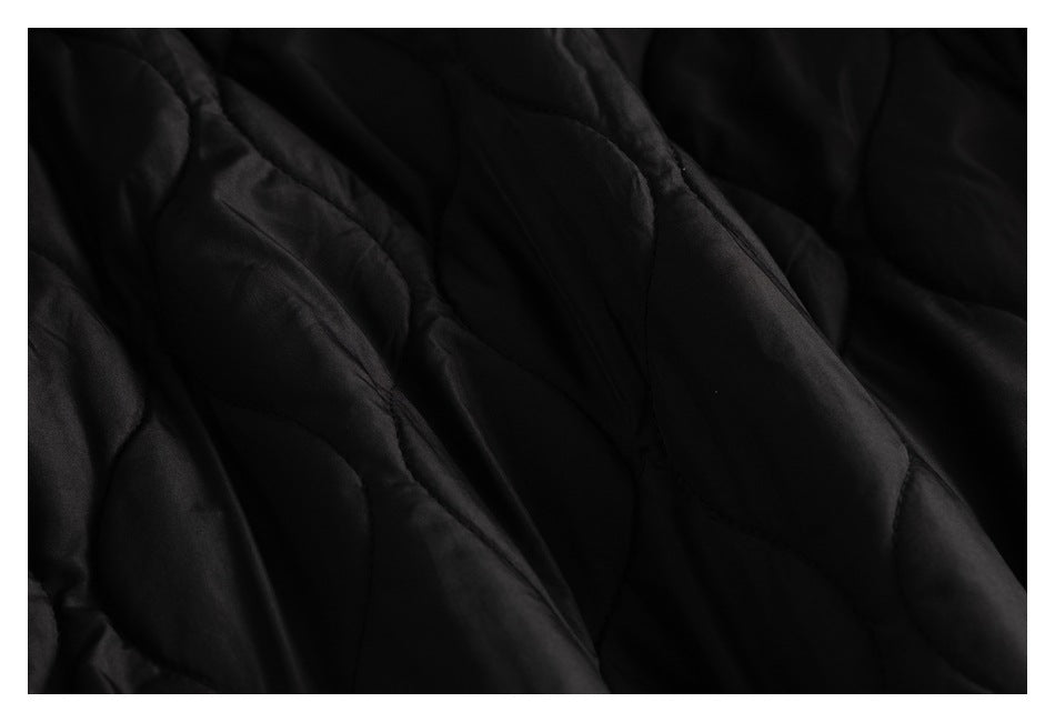 Close-up of black quilted jacket lining with curved stitched channels.
