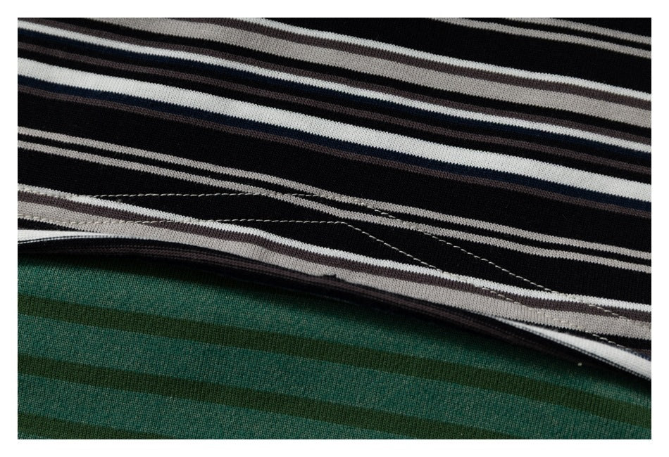 Close-up of the shirt's black-and-white striped panel meeting the green striped panel at a seam.