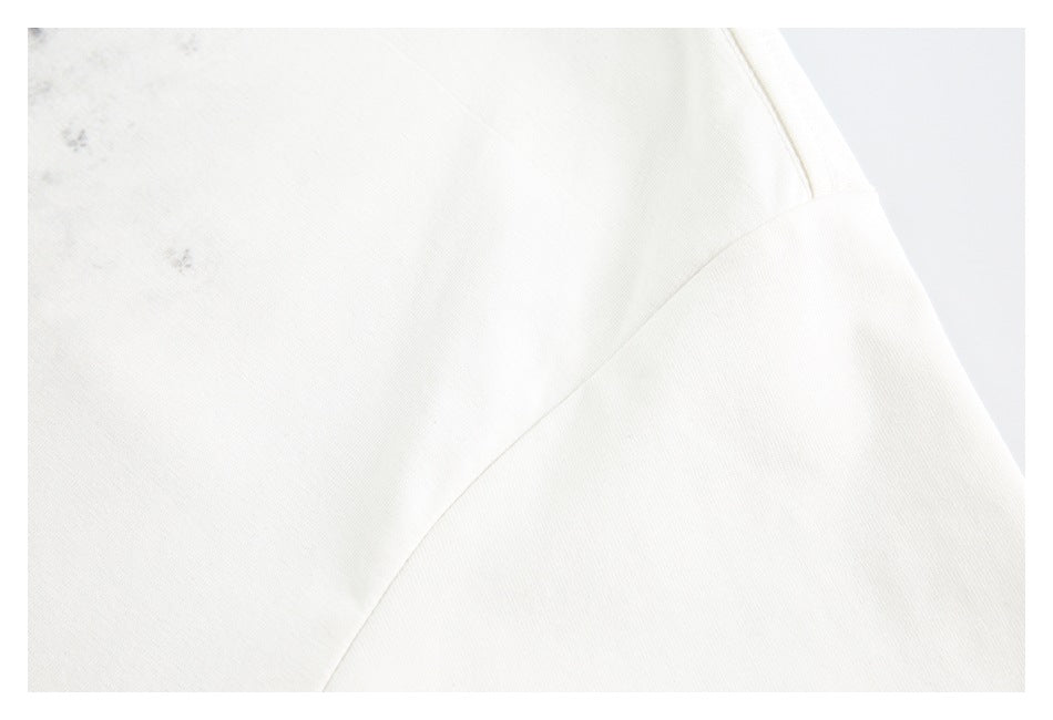 Close-up of off-white shirt fabric and a diagonal stitched seam.