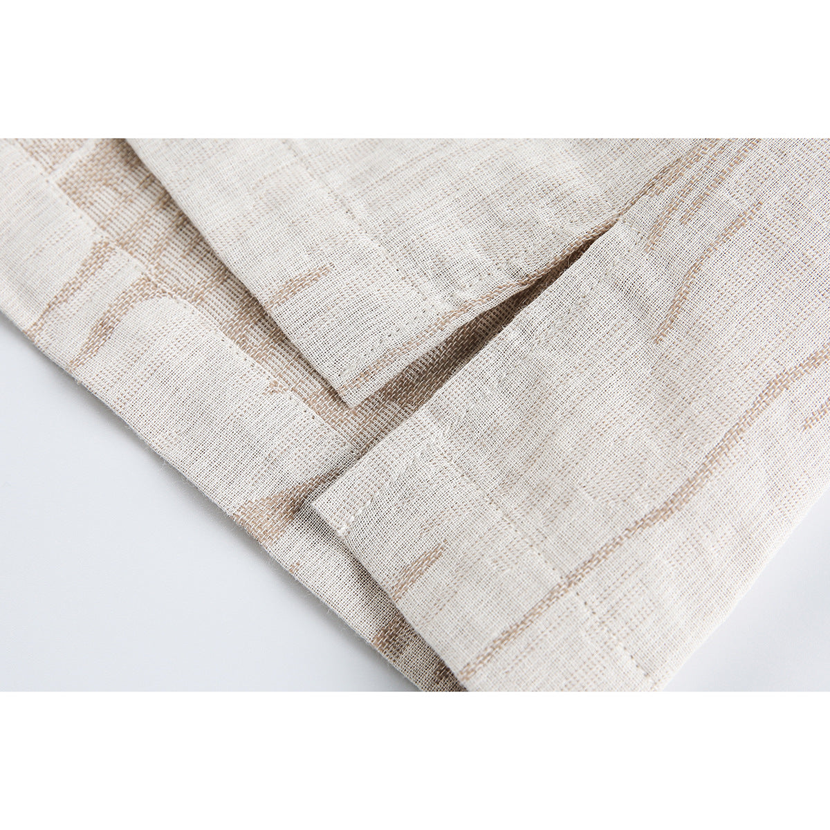 Close-up of the ivory jacket's tan patterned fabric and a stitched pocket opening.