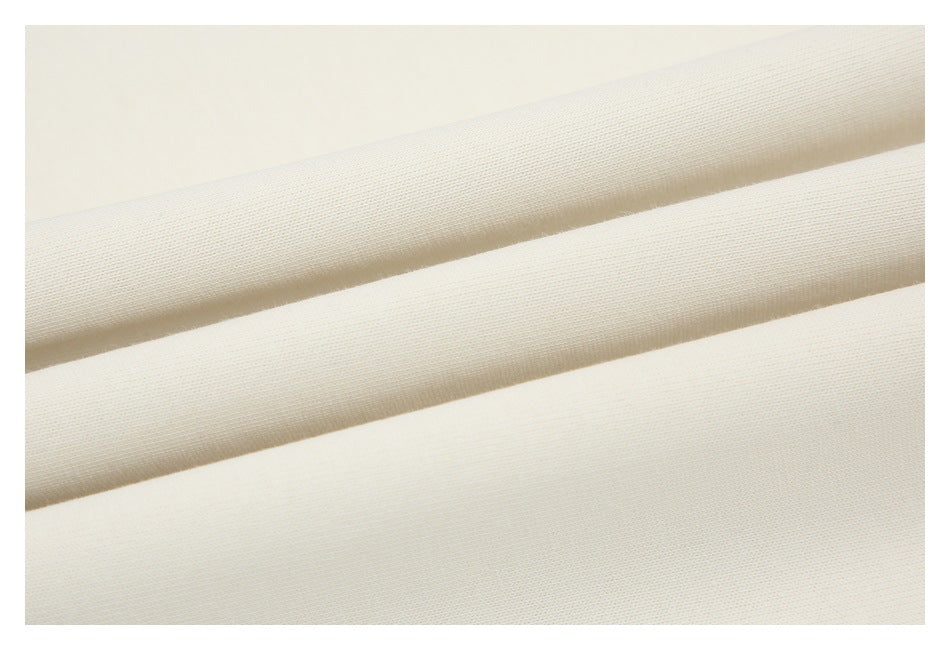 Close-up of off-white fabric folds showing the fine surface texture.