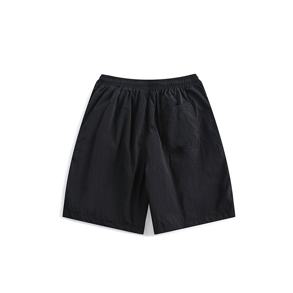Back view of black shorts with elastic waistband and a single patch pocket on the right