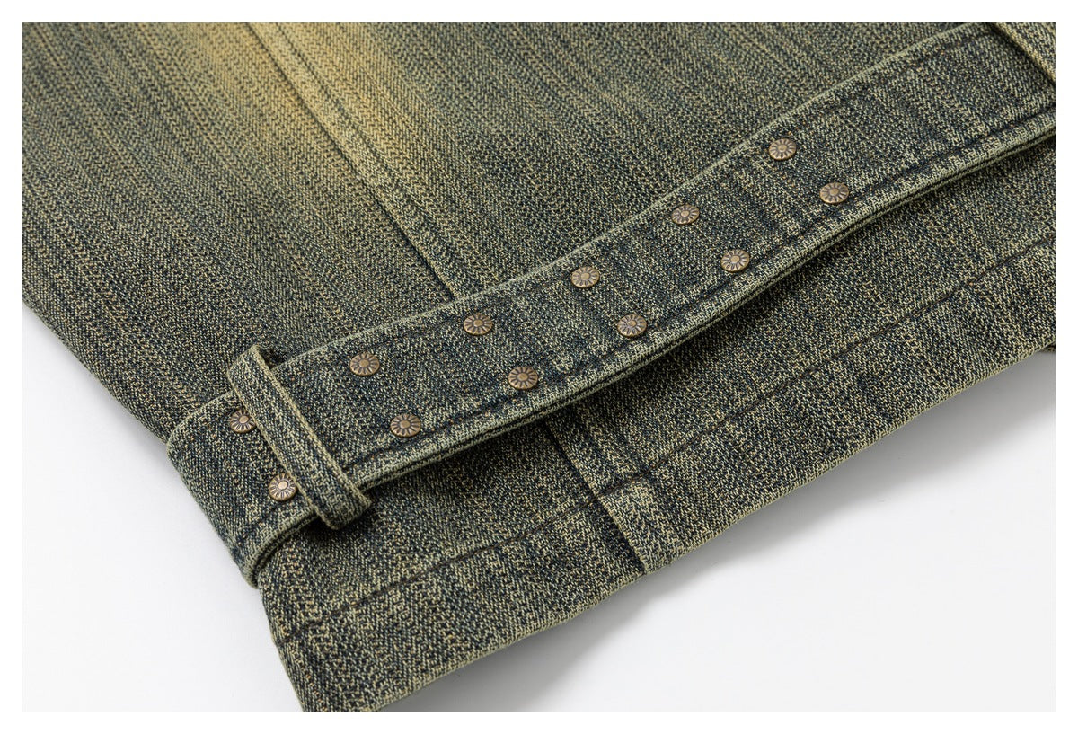 Close-up of a dark olive and tan textured garment with a narrow buttoned strap and stitched seams.