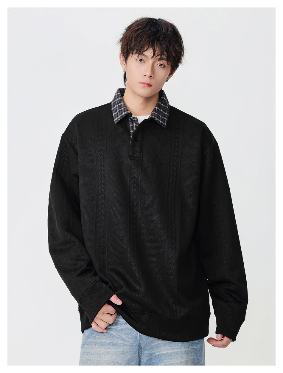 Model wearing an oversized black pullover with a plaid collar, button placket, and raised geometric patterns.