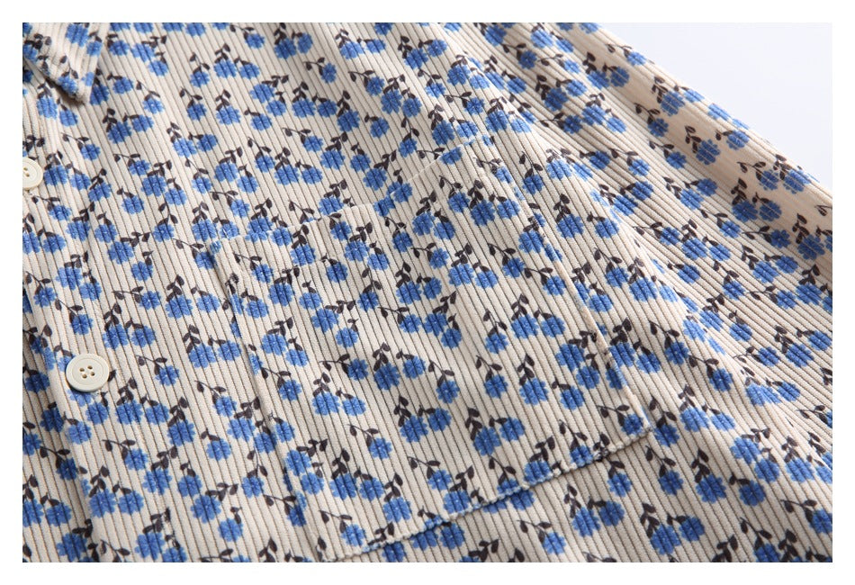 Close-up of the shirt's ribbed blue floral print and chest pocket seam.