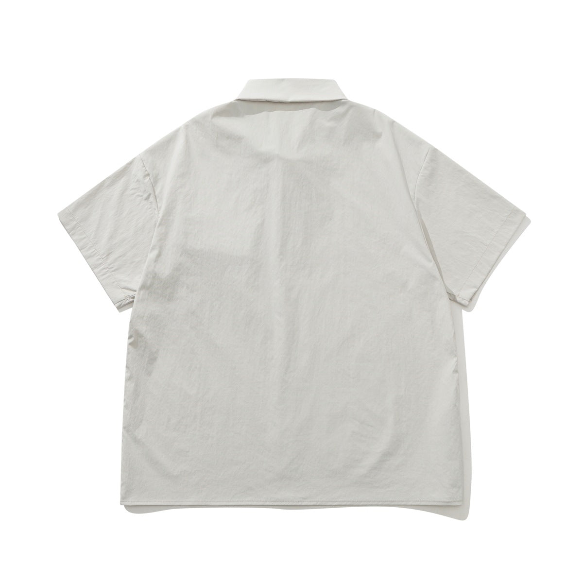 Back view of an off-white short-sleeve button-up shirt with a collar and straight hem.