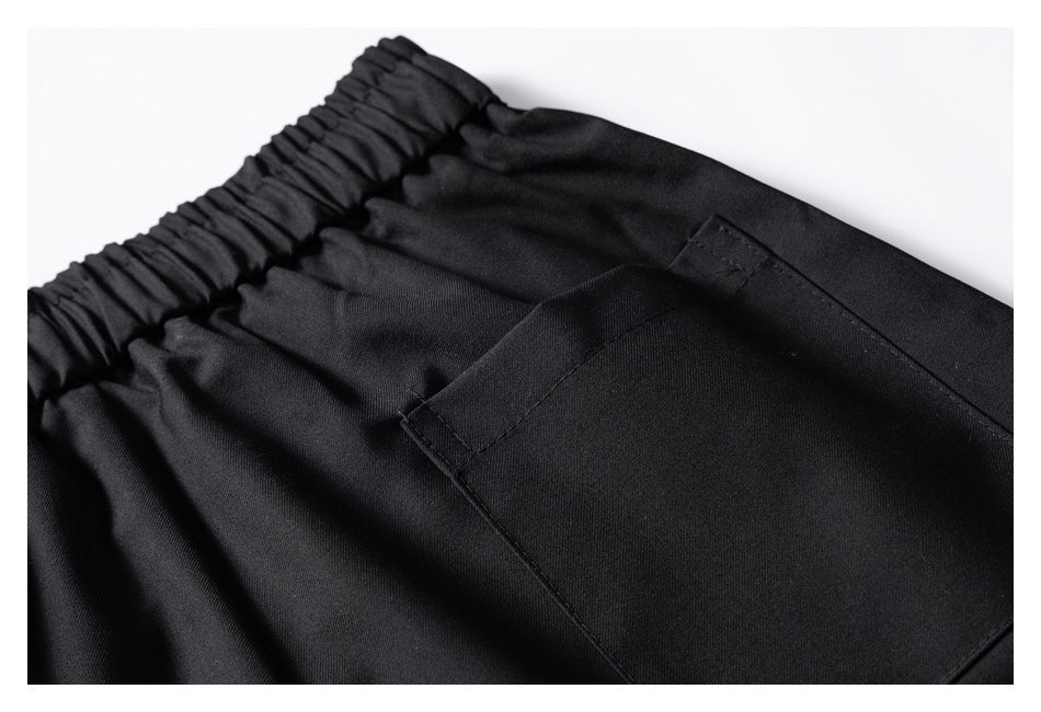 Close-up of black pants showing the elastic waistband and a large rectangular pocket.