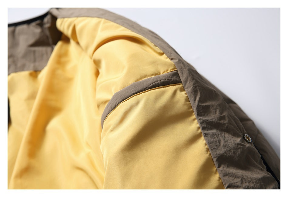 The taupe jacket is opened to show its bright yellow lining and inner seam detail.
