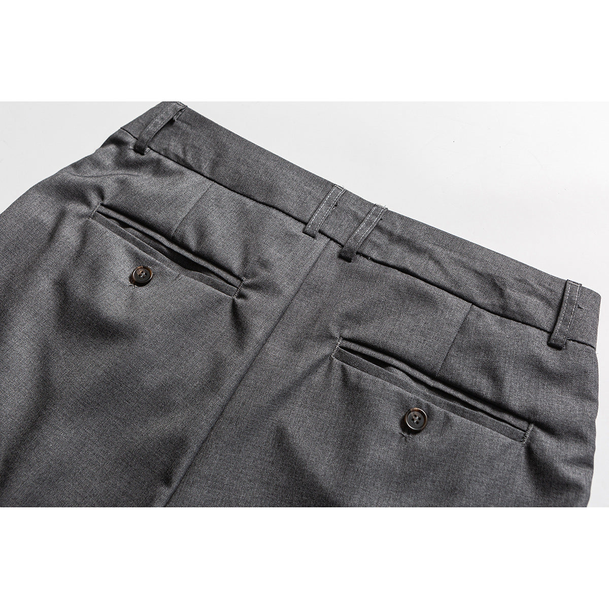 Back view of charcoal gray trousers with belt loops and two buttoned welt pockets.