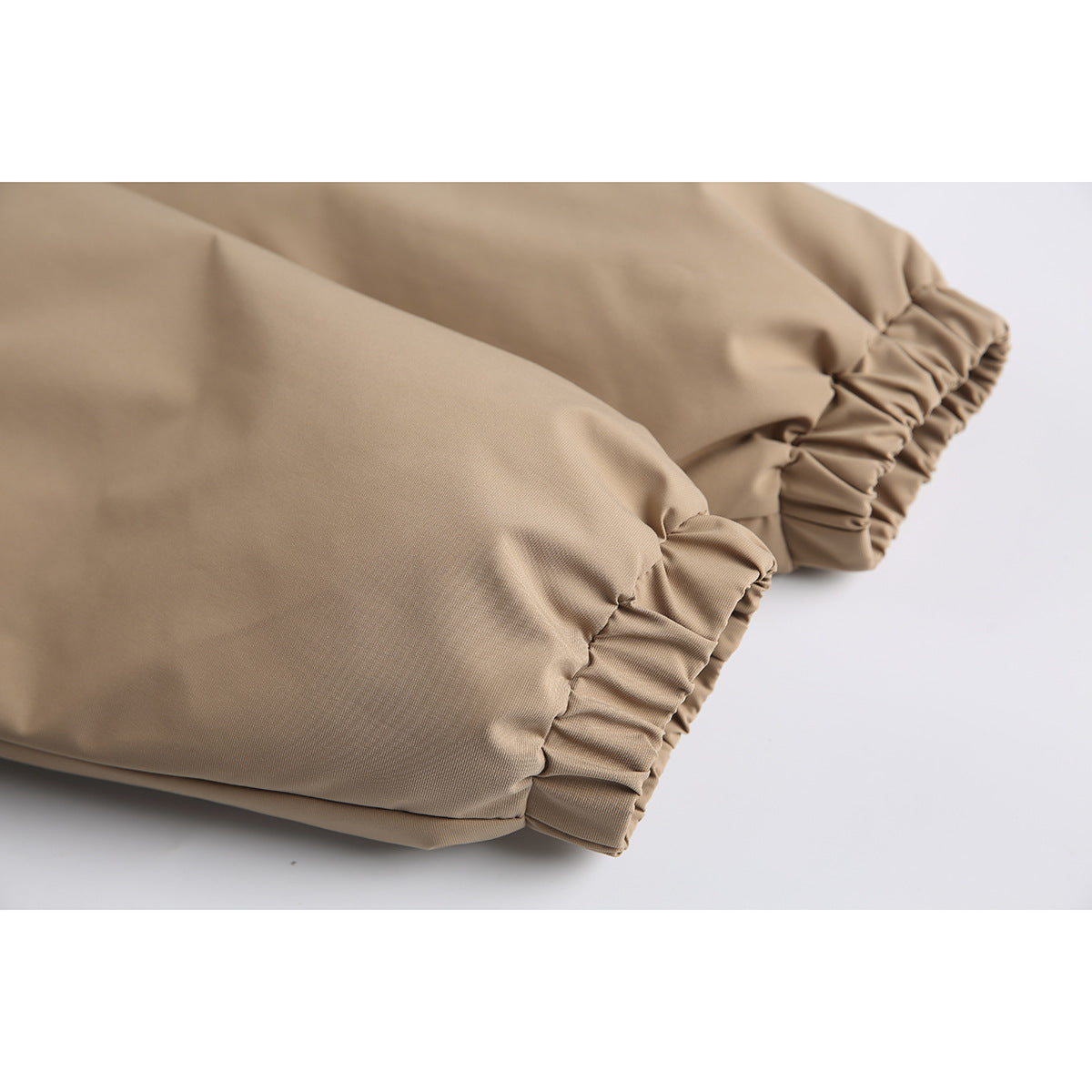 Close-up of a tan jacket sleeve with a gathered elastic cuff.