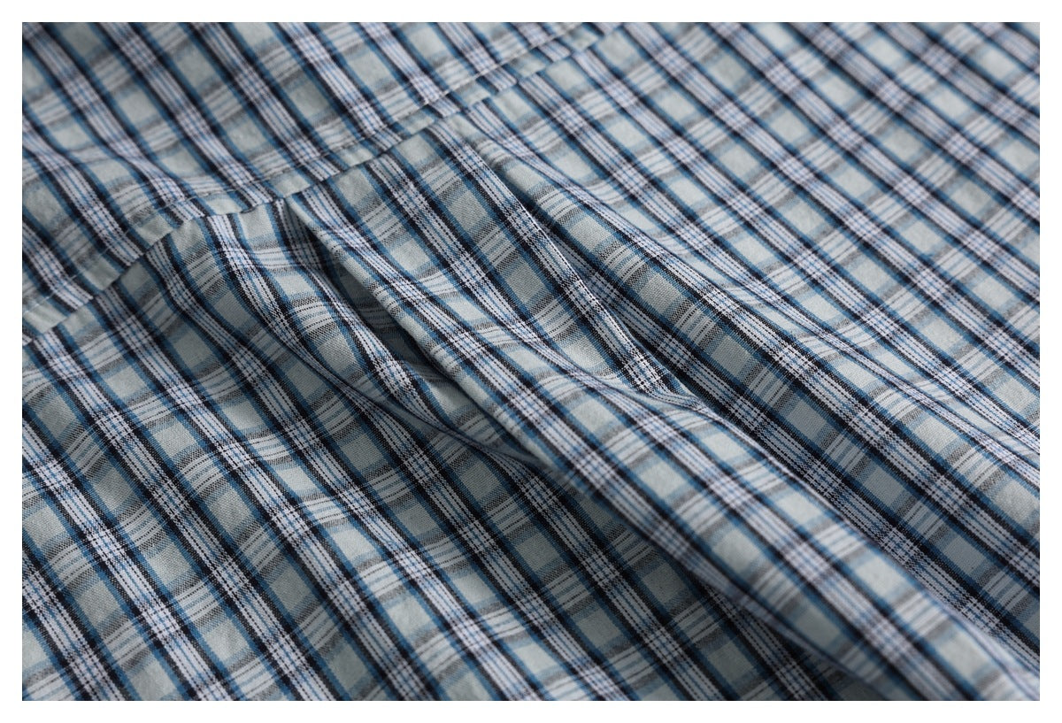 Close-up of the blue, gray, and white plaid pattern across the shirt fabric.