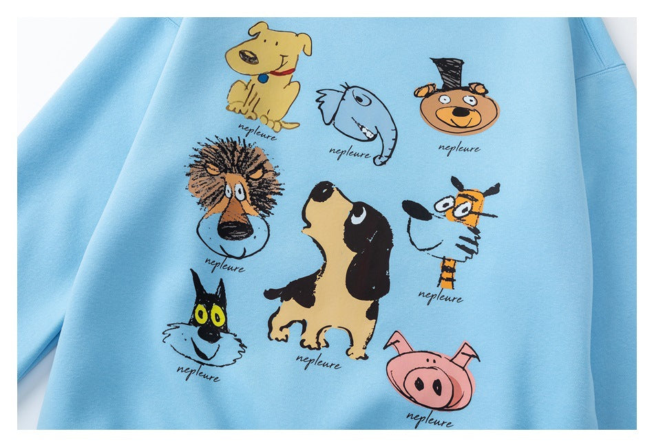 Close-up of a light blue sweatshirt's colorful cartoon animal print with small handwritten-style lettering.