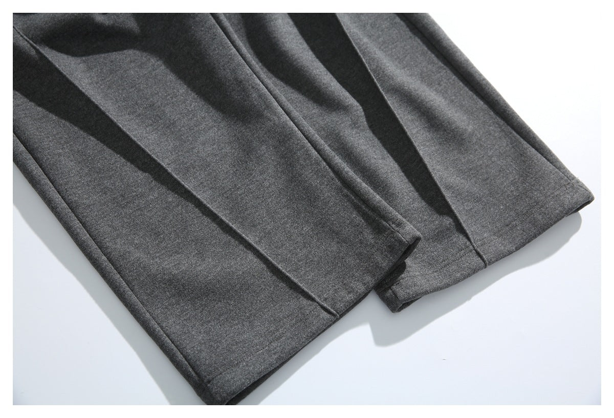 Close-up of charcoal gray pants showing two straight leg hems and stitched seams.