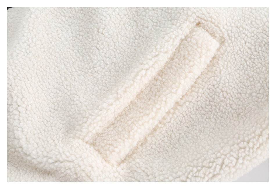 Close-up of an angled welt hand pocket on the ivory sherpa jacket.