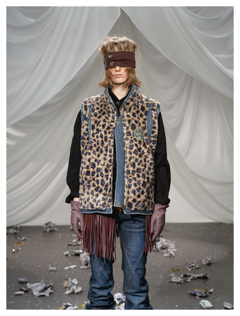 Closer front view of a model in a fuzzy leopard-print vest with denim edging and long burgundy fringe.