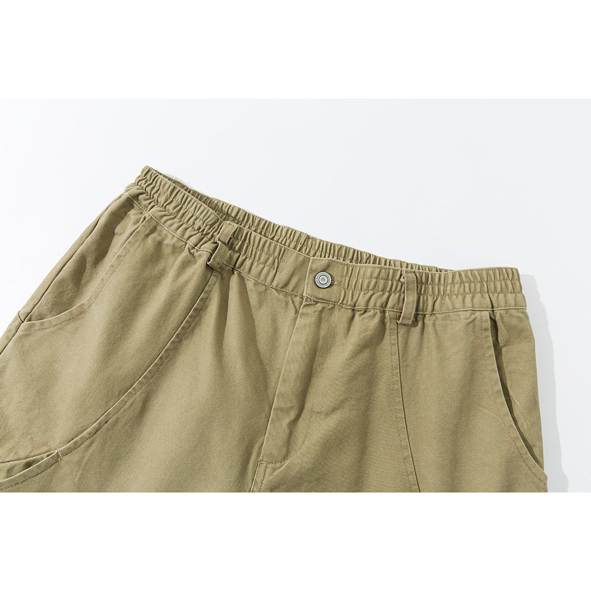 Close-up of khaki shorts showing an elastic waistband, button, belt loops, and curved front pockets.