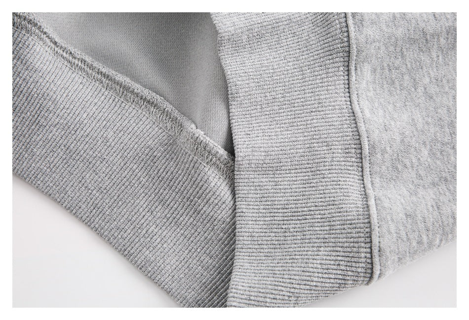 Close-up of ribbed trim and stitching on a heather-gray sweatshirt.