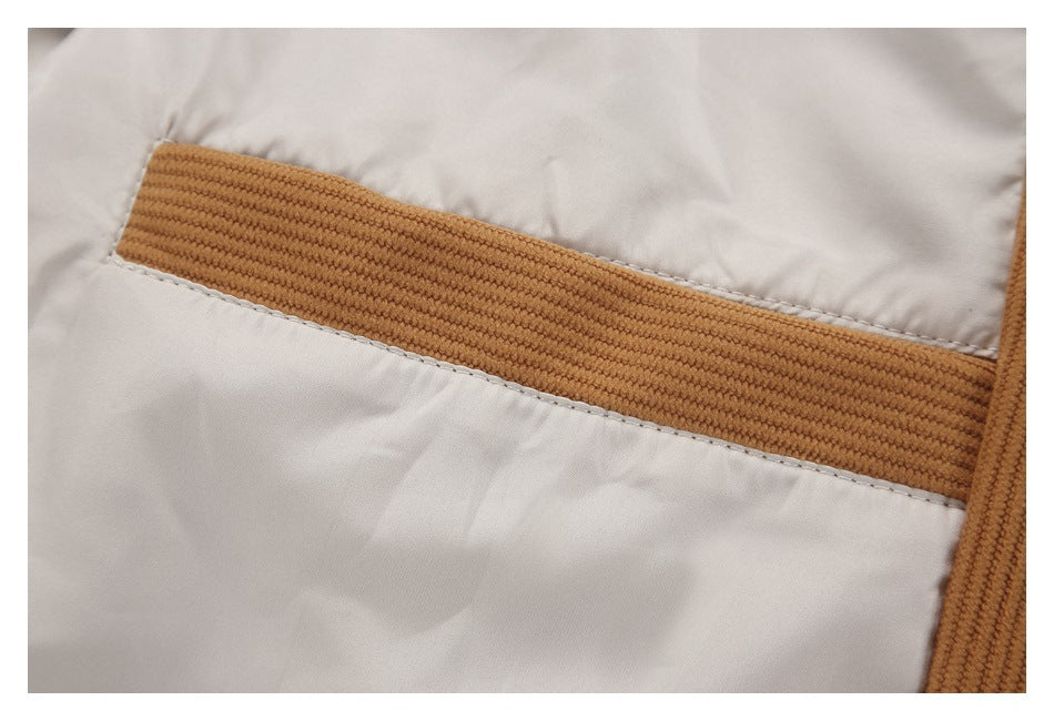 Close-up of a white garment with a wide tan ribbed trim band and visible stitching.