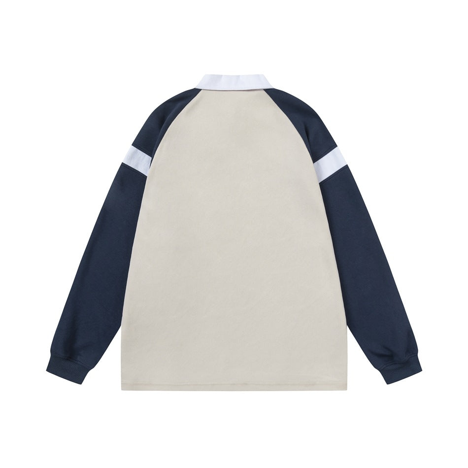 Back view of a cream-bodied top with navy raglan sleeves, white sleeve bands, and a white collar.