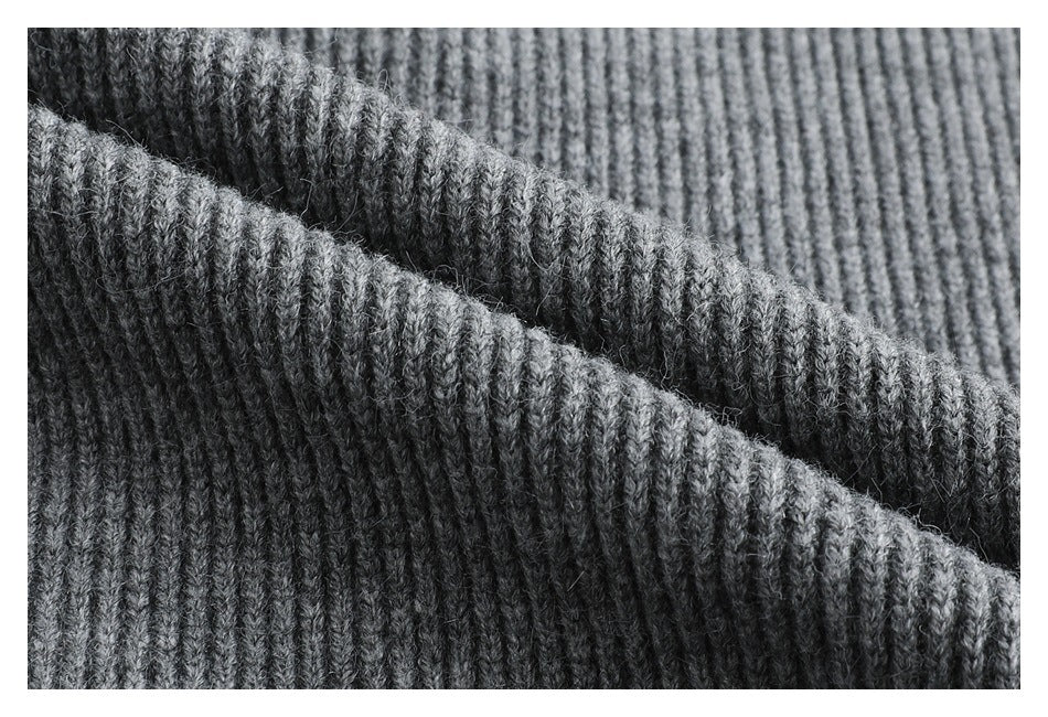 Macro view of gray rib-knit fabric folded to show its raised vertical texture.