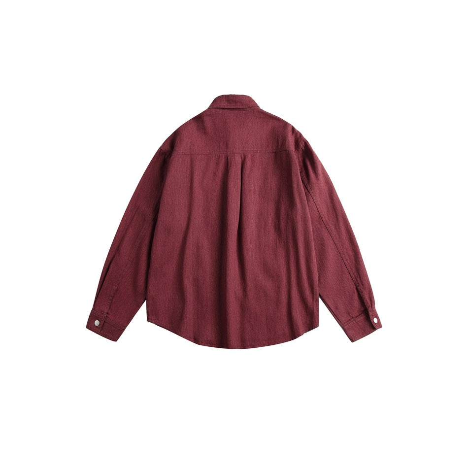 Back view of a burgundy long-sleeved overshirt with a center pleat and snap cuffs.