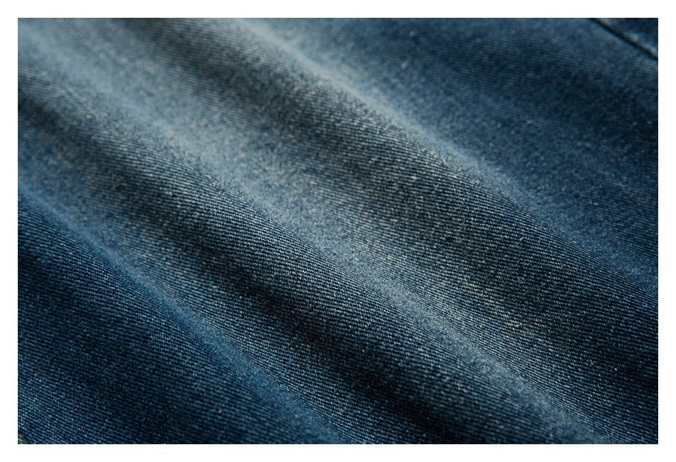 Macro view of the dark blue denim weave and faded diagonal areas.