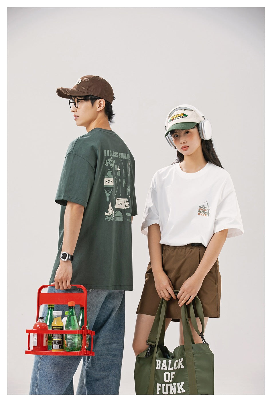 Two models show the front of a white graphic tee and the back graphic of a dark green tee.